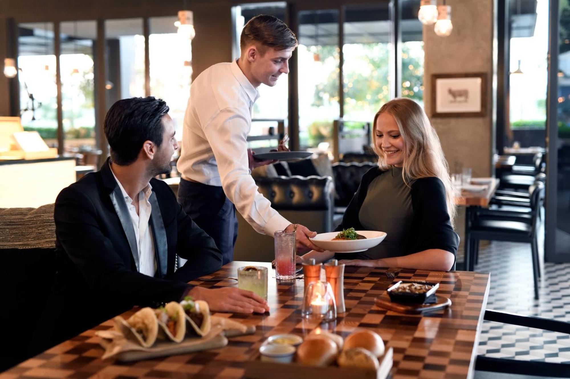 La Ville Hotel & Suites City Walk Dubai, Autograph Collection Eksteriør billede A waiter serving a couple
